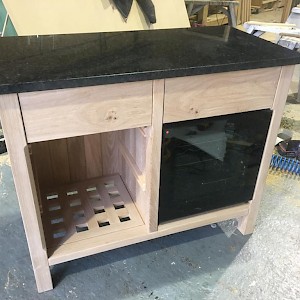 Handcrafted kitchen cabinet with wine storage solution.